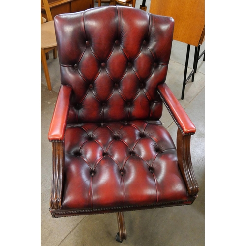 89 - A mahogany and oxblood red leather revolving desk Captains chair