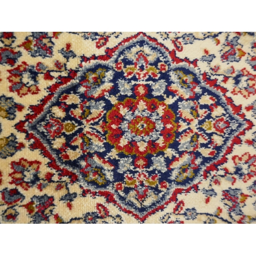 1325 - A red ground full pile Cashmere rug with floral medallion design, 170 x 120cm