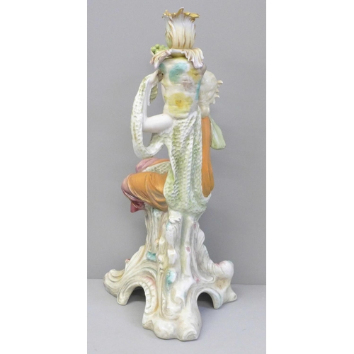 607 - A continental porcelain figural candlestick modelled as a girl seated on a tree stump holding up a b... 