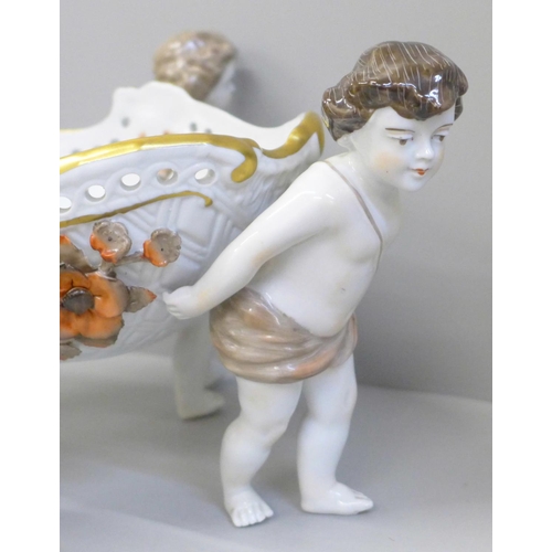 638 - A continental porcelain hand painted four cherub centrepiece, 34cm