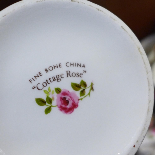 661 - A large quantity of Cottage Rose china, including a swan, iron, bell, vases, etc., two Staffordshire... 