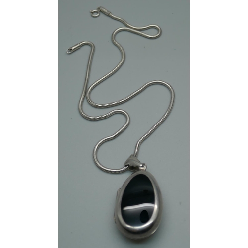 948 - A silver locket set with onyx on a silver chain