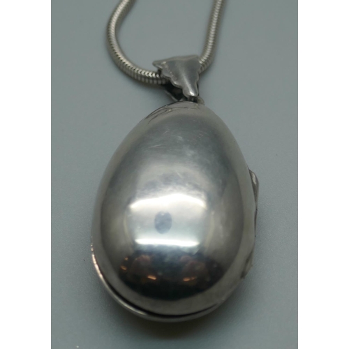 948 - A silver locket set with onyx on a silver chain