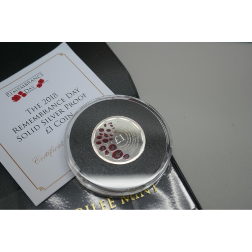 956 - A £5 coin, The World's First decimal circulating £5 coin, a £1 silver proof Remembrance Day 2018 coi... 