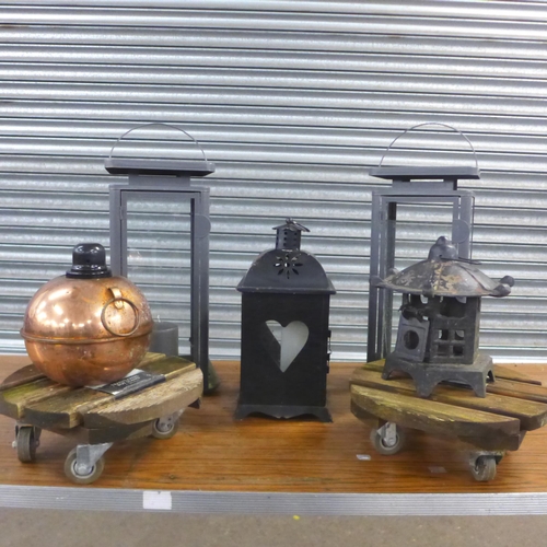 2257 - Various garden lamps, an oil lamp and 2 pot stands on wheels