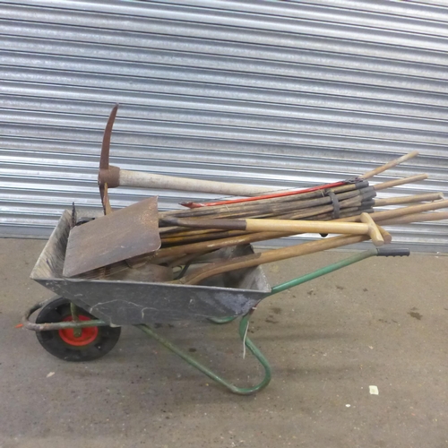 2281 - A metal wheelbarrow with garden tools including spades, pick axes, rake etc. and a quantity of drain... 