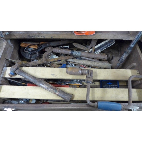 2024 - A wooden tool box containing saws, hammers, brace drill, scissors, rasp file, screwdrivers etc.