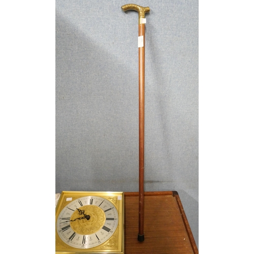 296 - An brass wall clock and a walking cane