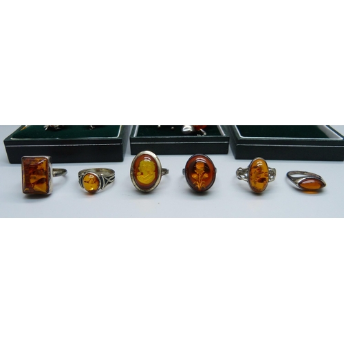 1046 - Six silver and amber rings, one with cameo of flower inlaid in the amber, a pair of amber earrings a... 