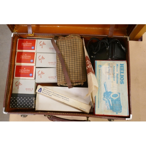 1140 - A small suitcase comprising eight boxes of colour slides (seven O), 2x¾ x 2¾, a Helios Macro Bellows... 