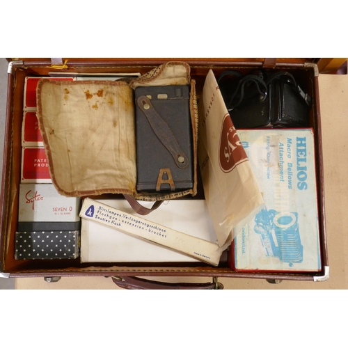 1140 - A small suitcase comprising eight boxes of colour slides (seven O), 2x¾ x 2¾, a Helios Macro Bellows... 