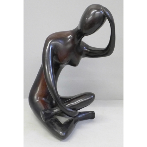 605 - An abstract bronzed figure of a seated lady