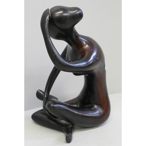 605 - An abstract bronzed figure of a seated lady