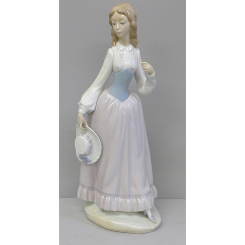 611 - A Lladro figure of a girl with hat, lacking parasol