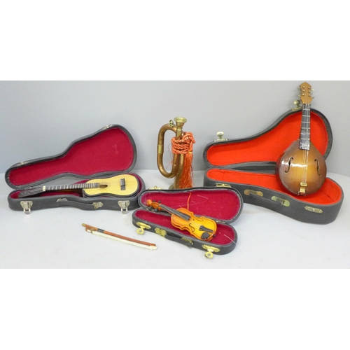 636 - Four miniature instruments, two classical guitars, a violin and a bugle