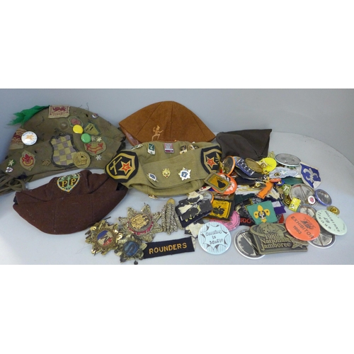 764 - A collection of badges, patches and hats including some military related
