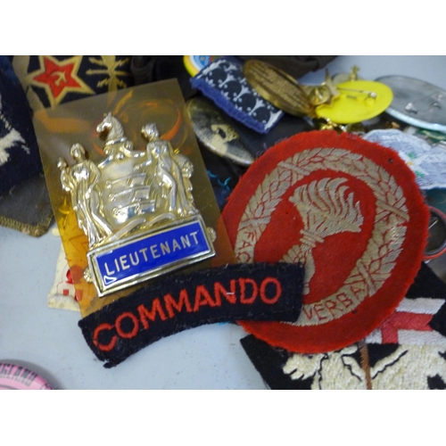 764 - A collection of badges, patches and hats including some military related