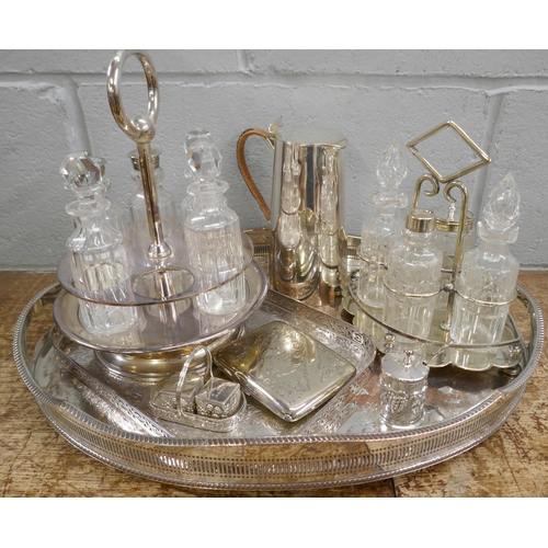 812 - Two plated gallery trays, a water jug, a plated purse, cruets and condiments