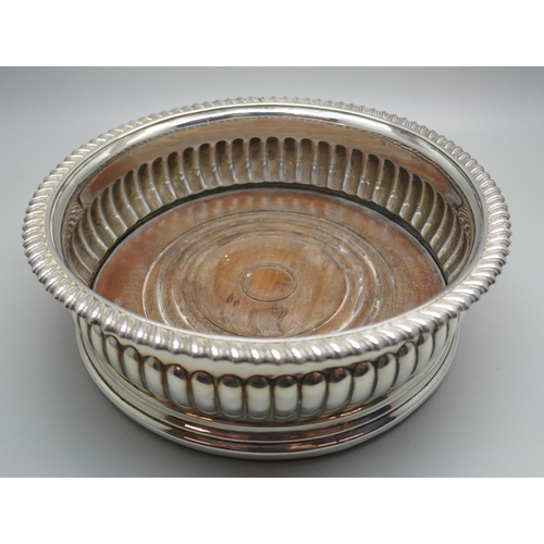 833 - A silver wine coaster with wooden base, London 1816, 17cm diameter