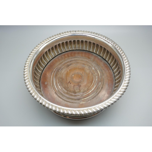 833 - A silver wine coaster with wooden base, London 1816, 17cm diameter