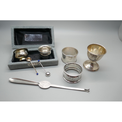 859 - A silver lobster pick, two silver napkin rings, a weighted silver egg cup and two salts with spoons,... 