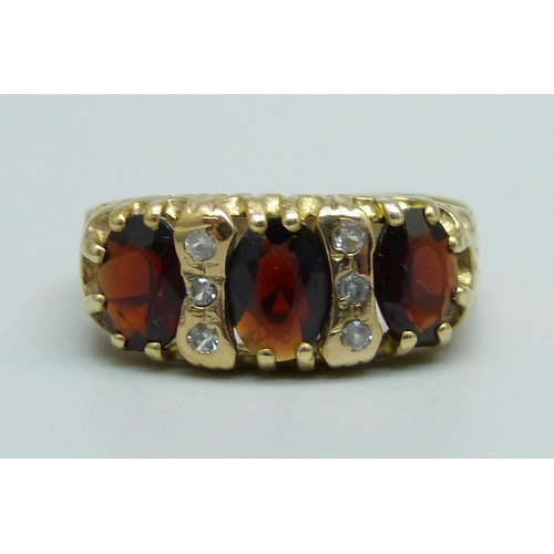 928 - A 9ct gold, garnet and white stone ring, 3.4g, S