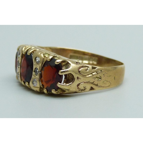 928 - A 9ct gold, garnet and white stone ring, 3.4g, S