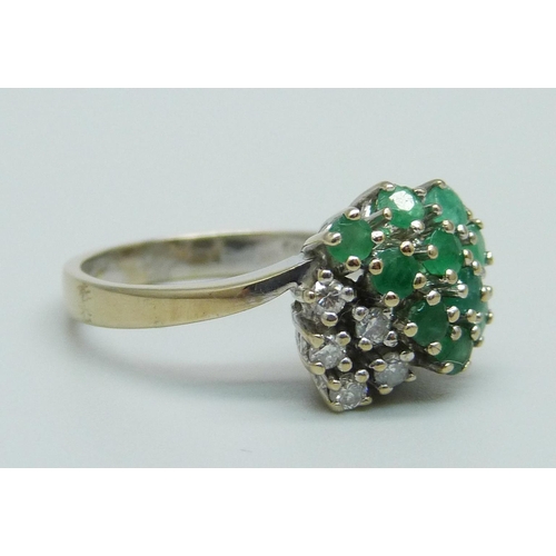 959 - An 18ct gold, emerald and diamond cluster ring, 4.9g, O