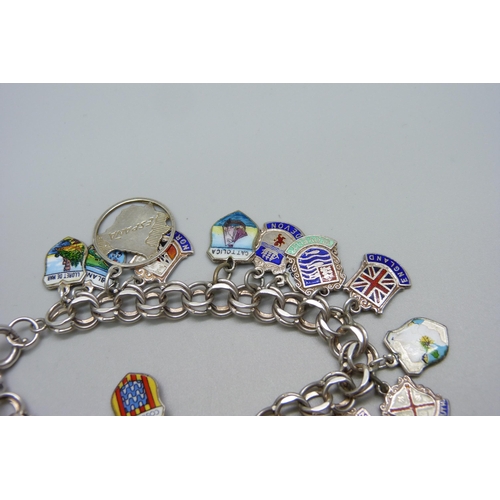 993 - A sterling silver double link charm bracelet with enamelled tourist charms and some loose charms, 43... 