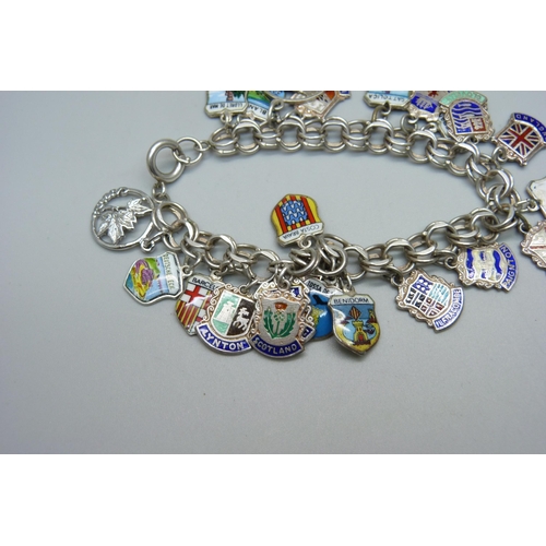 993 - A sterling silver double link charm bracelet with enamelled tourist charms and some loose charms, 43... 