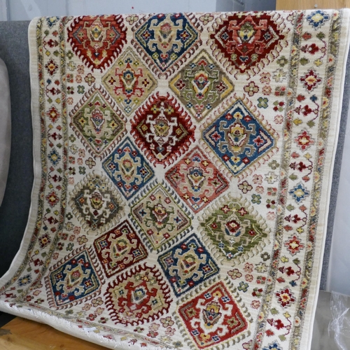 1445 - A cream ground all over diamond design rug, 170 x 120cm