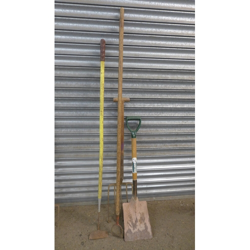 2255 - 8 Assorted garden tools in a green plastic bin including spades, pitch forks, hoes etc.