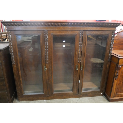 204 - A late Victorian carved oak three door bookcase