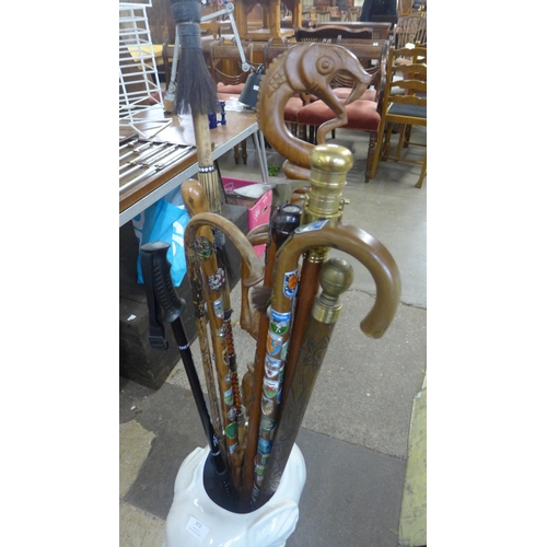 372 - A collection of walking sticks and a pot elephant stick stand, includes pool cue, telescope, etc.