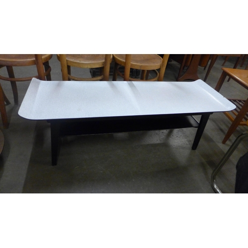 76 - A Formica and black sleigh top coffee table
