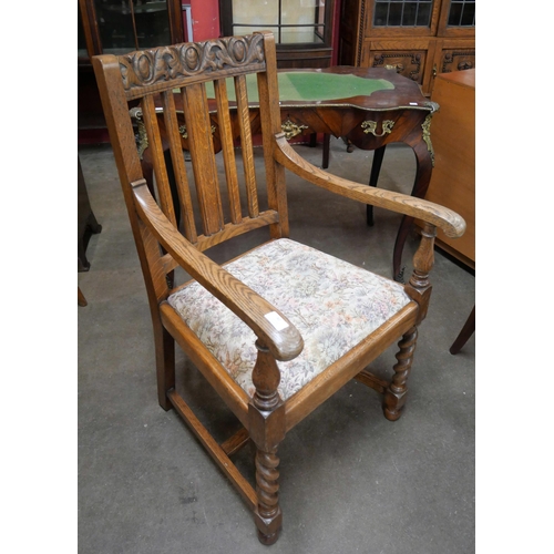 82 - An early 20th Century carved oak barleytwist elbow chair