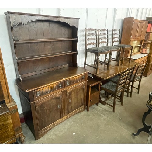 139 - An oak eight piece dining suite, comprising; refectory table, six chairs, dresser and a pot cupboard