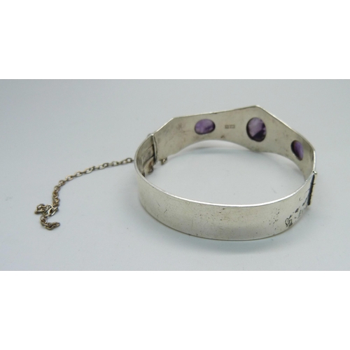 1002 - A hallmarked silver bangle set with cabochon amethyst, Birmingham 1971, Excalibur, 27g