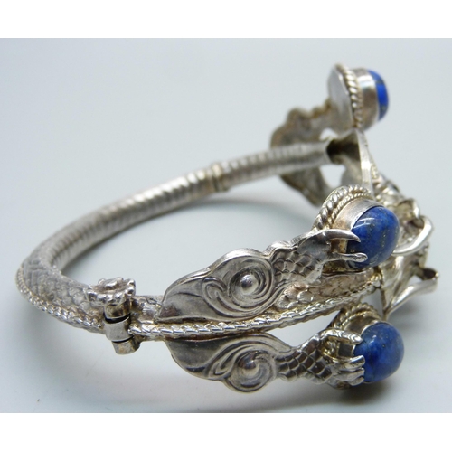 1049 - A white metal, lapis lazuli bangle with dragon detail