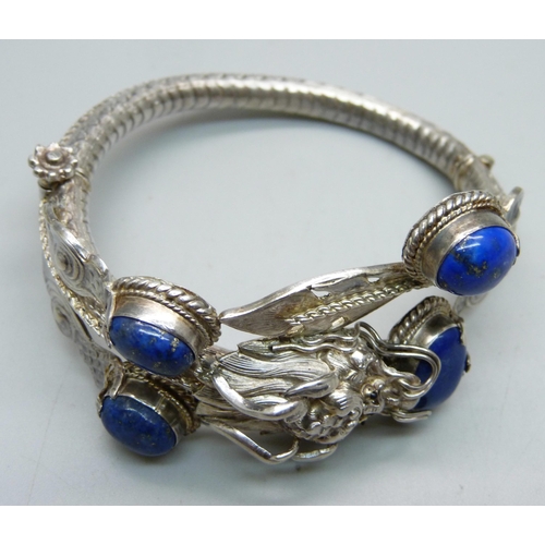 1049 - A white metal, lapis lazuli bangle with dragon detail