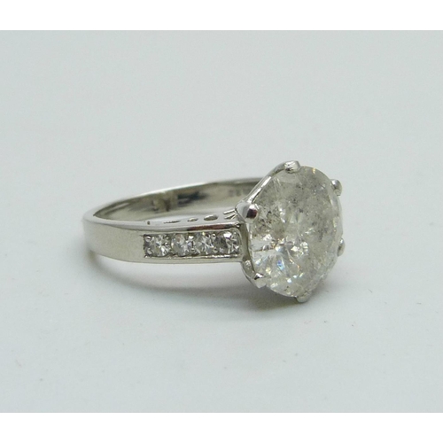 1056 - A hallmarked platinum solitaire diamond ring with diamond set shoulders, 3.80cts, 6.1g, M