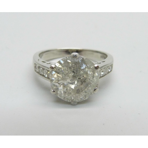 1056 - A hallmarked platinum solitaire diamond ring with diamond set shoulders, 3.80cts, 6.1g, M