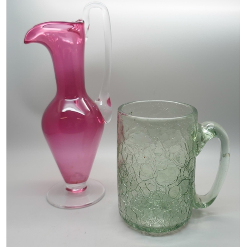 657 - A cranberry glass ewer/vase and a crackle glass mug