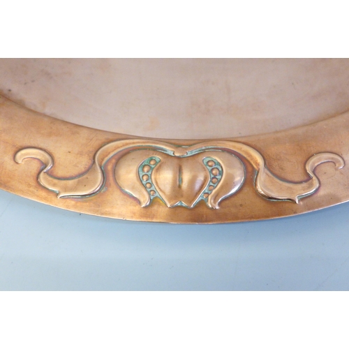 679 - An Arts and Crafts oval copper platter, 36cm wide