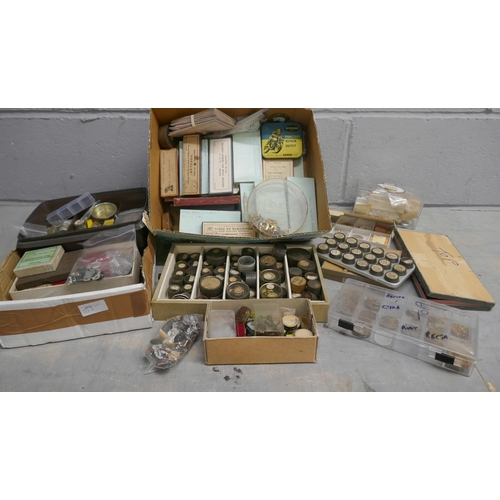 701 - Two boxes of watch materials including main springs, crowns, rotor wheels, etc. **PLEASE NOTE THIS L... 