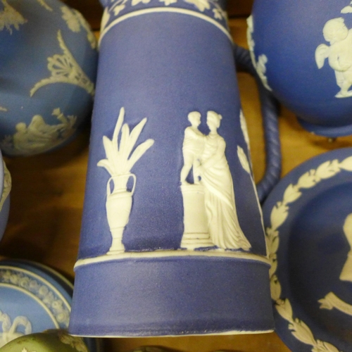 740 - A box of Wedgwood Jasperware including a pair of dark blue candlesticks, jug and vase