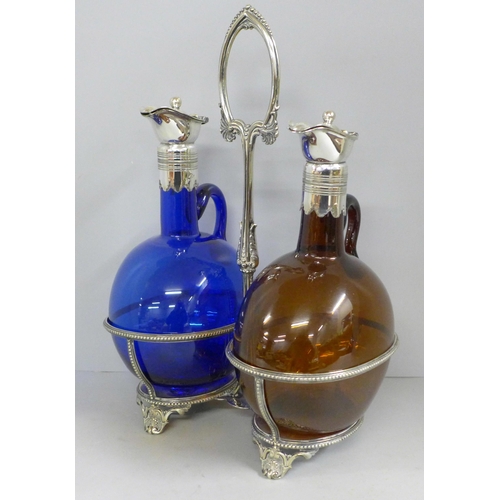 828 - A pair of oil bottles with plated tops, blue and brown glass, on a plated stand