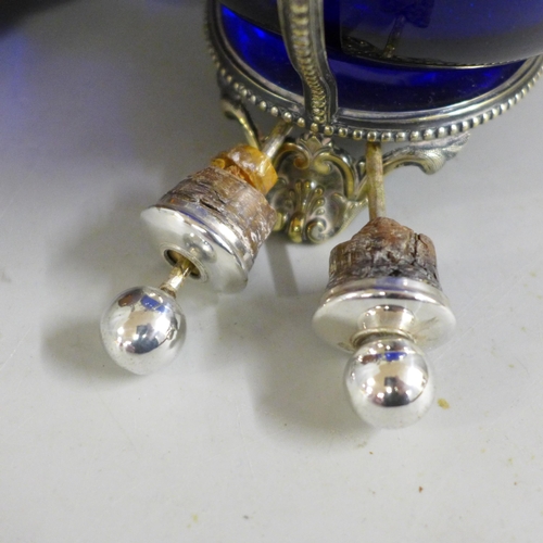 828 - A pair of oil bottles with plated tops, blue and brown glass, on a plated stand