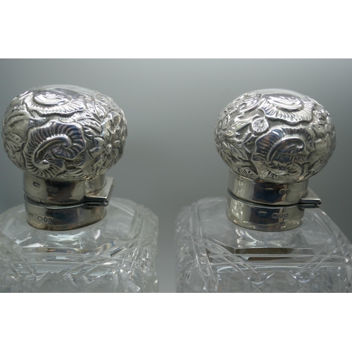 862 - A pair of Victorian silver topped glass decanters, with hinged tops and inner stoppers, London 1890,... 