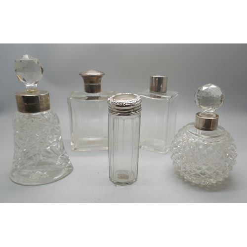 885 - Five silver topped/mounted dressing table bottles, one with continental marked, one top dented